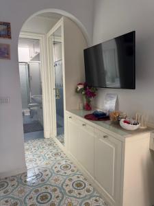 a bathroom with a shower and a television on a cabinet at Capri Suite Dreams in Capri