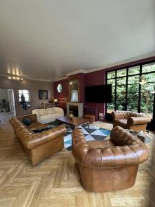 a living room with leather furniture and a living room with a fireplace at Erawan Boutique Hôtel in Évreux