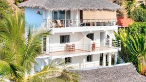 an aerial view of a white building with a thatch roof at Villa Razambe in Mandriankeniheny