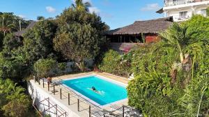 a person swimming in a swimming pool next to a house at Villa Razambe in Mandriankeniheny