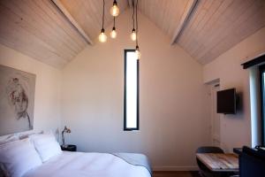 um quarto com uma cama branca e uma janela em Belle Chique - Maastricht em Lanaken