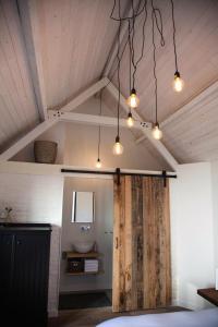 Cette chambre dispose d'une salle de bains avec une porte en bois et des lumières. dans l'établissement Belle Chique - Maastricht, à Lanaken