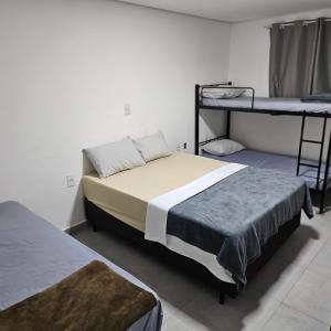 two beds in a room with two bunk beds at Hotel Rei in São Bernardo do Campo