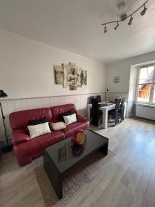 a living room with a red couch and a table at Riquewihr in Riquewihr