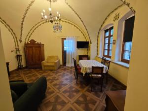 a living room with a table and chairs and a chandelier at Pałac Książęcy we Wleniu in Wleń