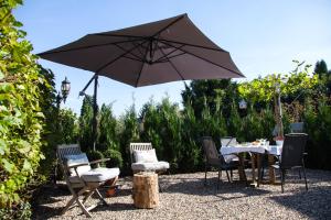 拉納肯的住宿－Belle Chique - Maastricht，花园内桌椅和遮阳伞