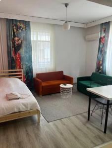 a room with a bed and a couch and a table at Soydan World Travel in Antalya