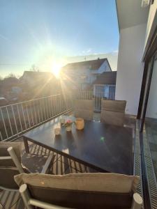 a table and chairs on a balcony with the sun setting at Apartment Romi in Bad Waldsee +6 photos