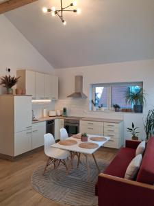 a kitchen and living room with a table and a couch at Apartment Romi in Bad Waldsee