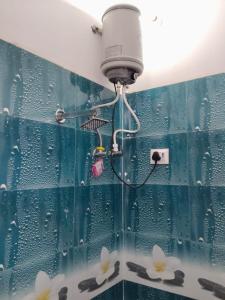 a blue tiled bathroom with a shower with white flowers at Hotel Maa Bhagvati in Orchha