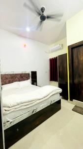 a bedroom with a bed with a ceiling fan at Hotel Maa Bhagvati in Orchha