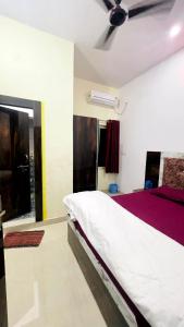 a bedroom with a bed and a ceiling fan at Hotel Maa Bhagvati in Orchha
