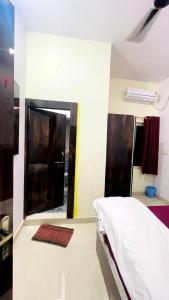 a bedroom with a bed and a mirror in it at Hotel Maa Bhagvati in Orchha +5 photos