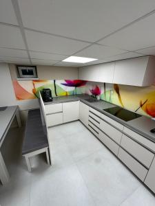 a kitchen with colorful cabinets and a table and a chair at Fully Equipped Guest House Košice-Barca in Košice