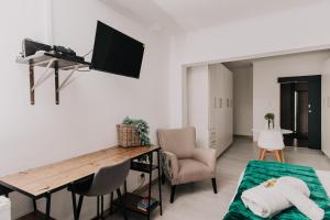 a living room with a desk and a tv on a wall at Seek First B&B in Pretoria
