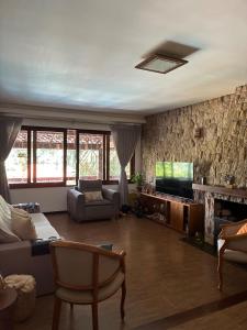 a living room with a couch and a television at Casa Au Clair de Lune Terê in Teresópolis