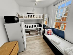 a small room with a bed and a refrigerator at London Duo & Quad Rooms in Zone 2 - Willesden Green in London +14 photos
