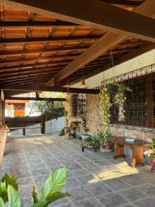 a patio with a wooden roof with a wooden table at Casa Au Clair de Lune Terê in Teresópolis
