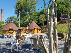 a picnic table and chairs in front of a log cabin at kotaventure romantique in Le Mesnil-Villement