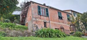 an old red brick building with green shutters on it at Casa del contadino in Rapallo