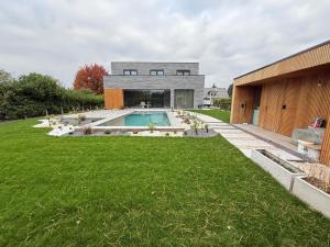 a house with a swimming pool in the middle of a yard at Executive Villa with pool in Londerzeel