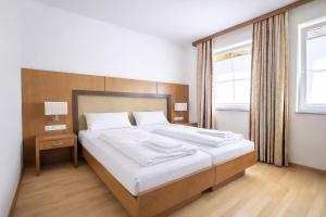a bedroom with a large bed and a window at Mühlengarten by Zzzimple in Nittel