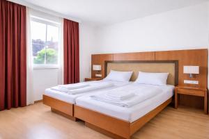 a bedroom with a large bed with white sheets at Mühlengarten by Zzzimple in Nittel
