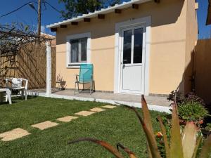 a house with a white door and a blue chair at Vasiliki Little House in Kanoni +14 photos