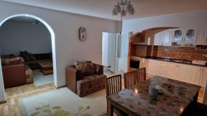 a kitchen and living room with a table and a couch at Villa Oaza Vilenjak in Visoko
