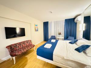 a hotel room with a large bed and a couch at New Orbi City Luxury Suites in Batumi