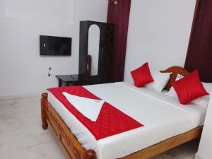 a bedroom with a large bed with red pillows at HoTEL K7 in Chennai