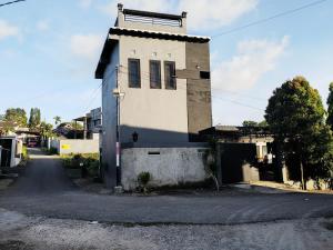 a white building with a window on a street at Little Loti Sikumana in Maulafa