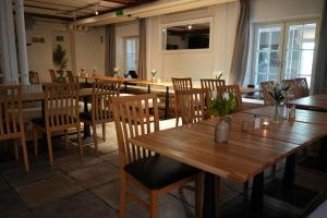 a dining room with wooden tables and chairs at Norrqvarn Hotel & Resort by Vänerport in Lyrestad