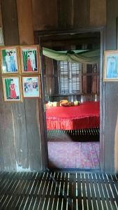 a bedroom with a red bed and pictures on the wall at Homestay in Kampong Cham in Kampong Cham