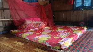 a bed in a room with a red blanket on it at Homestay in Kampong Cham in Kampong Cham