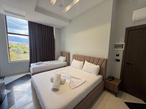 a hotel room with two beds and a window at OLI Hotel in Fushë-Krujë