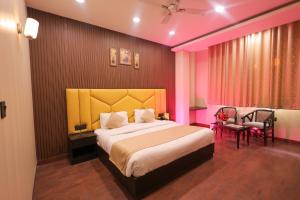 a bedroom with a large bed and a chair at Hotel Krishnam Vrindavan in Vrindāvan +117 photos