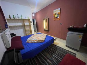 a bedroom with a blue bed and red walls at Cabana House in Dahab