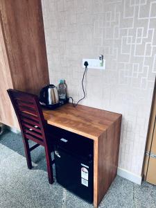 a wooden table with a pot on it next to a chair at Celestial Heights Kakkanad in Cochin +16 photos