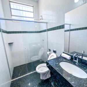a bathroom with a toilet and a sink and a shower at Pousada Grande Rio in Pirapora +67 photos