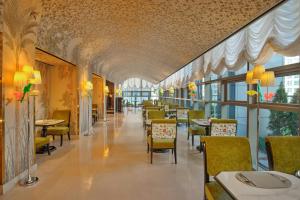 a dining room with tables and chairs and windows at L'Escape, a Luxury Collection Hotel, Seoul Myeongdong in Seoul