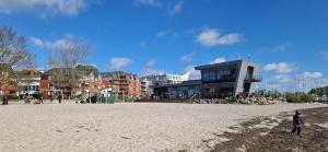 a person standing on the beach in front of a building at Ostsee No8 Eckernförde in Eckernförde