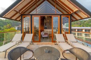 an outdoor patio with white chairs and a table at Casa Tartaruga in Unawatuna