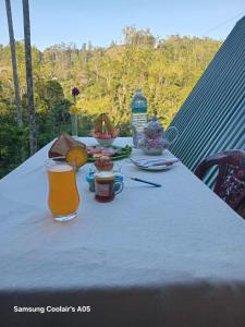 a table with food and a glass of orange juice at Ella Cool Air Cabana in Ella