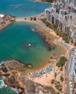 an aerial view of a beach with umbrellas and the ocean at VR requinte total ar e garagem in Guarapari