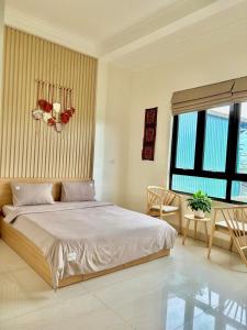 a bedroom with a bed and a table and chairs at Pá Homestay - Thành phố Cao Bằng in Cao Bằng