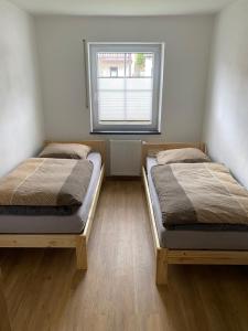 two beds in a room with a window at Ferienwohnung unterm Äpflet in Furth im Wald