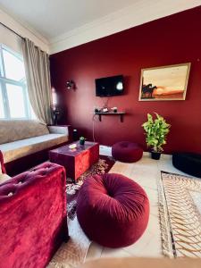 a living room with red walls and red furniture at Cabana House in Dahab