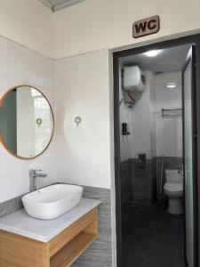 a bathroom with a sink and a toilet and a mirror at Pá Homestay - Thành phố Cao Bằng in Cao Bằng