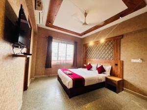 a hotel room with a bed and a television at Celestial Heights Kakkanad in Cochin